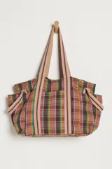 Bolso tote de gran capacidad confeccionado en tela con estampado a cuadros en tonos marrones, rosas, celestes y amarillos. Cuenta con dos asas largas de hombro y bolsillos laterales.