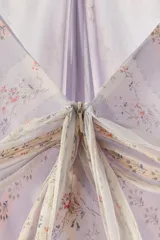 Vestido largo de viscosa con estampado de rayas diagonales florales, cuello halter ajustable con botones y escote en V. Cuenta con tirantes dobles, forro interior y cierre trasero con cremallera oculta.