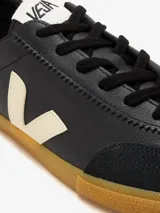 Championes Veja modelo Volley, de color negro con detalles en crema. Presentan el logo lateral característico de la marca en contraste, puntera reforzada de gamuza y suela de goma color caramelo.