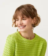 Blusa de punto color verde lima, de manga corta y cuello redondo. Presenta un diseño con textura de relieve en todo el cuerpo y terminaciones acanaladas en cuello, puños y cintura.