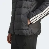 Campera puffer Adidas de corte clásico, color negro con cierre frontal completo y cuello alto. Presenta el logo de la marca en el pecho y las icónicas tres tiras blancas en las mangas. Cuenta con tecnología Climawarm para aislamiento térmico y puños elásticos.