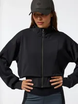 Canguro negro con cremallera, confeccionado en tejido con tecnología Aloe Vera, cuello alto y mangas largas con puños ajustados. Presenta un diseño corto con chaleco incorporado elástico y ajustable en la cintura.