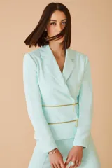 Blazer color amarillo con doble cierre dorado en la parte inferior.