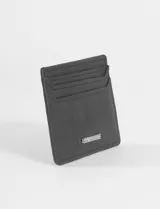 Tarjetero de cuero vegano con textura gamuzada, cuenta con ranuras para tarjetas y logo metálico de la marca en el frente.