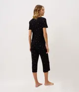 Pijama largo negro de viscolycra con estampa floral, compuesto por una remera de manga corta con escote en V y aplicación de encaje, y un pantalón con cintura elastizada.