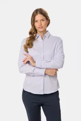 Camisa de manga larga entallada, confeccionada en una mezcla de algodón con spandex. Presenta cuello clásico, cierre frontal con botones al tono y puños abotonados.
