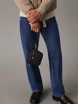 Riñonera negra de poliéster reciclado con correa ajustable con clip, cierre de cremallera en la parte superior y dos bolsillos exteriores en la parte delantera con anillas en D. Se pliega y se cierra con cremallera para crear una cartera para la muñeca.