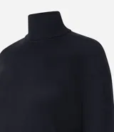 Vestido de punto negro, de manga larga y cuello alto, con corte recto y largo midi.