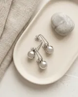 Caravanas colgantes de acero inoxidable con diseño de gancho tipo alfiler y esfera metálica pulida.