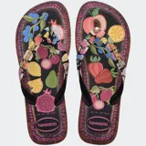 Ojotas Havaianas Top Tropicalia Vibes II con base negra y estampado de frutas tropicales en colores vibrantes. Las tiras son negras con el logo de Havaianas en dorado.