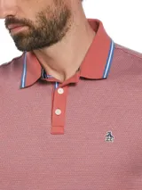 Polo de piqué color ladrillo con diseño jacquard, cuello clásico con vivo en contraste y logo de pingüino bordado en el pecho.