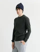 Sweater de punto con textura waffle, color negro, de corte clásico con cuello redondo y mangas largas con puños ajustados.