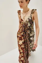 Vestido largo con escote en V profundo y tirantes con volados. Presenta un diseño patchwork con diferentes estampados florales y texturas en tonos tierra, negro y dorado metalizado.