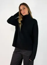 Sweater de tejido de punto color negro, con cuello alto, manga larga y puños y ruedo acanalados.