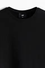 Remera de algodón liviano color negro, con cuello redondo y mangas cortas, de corte entallado.