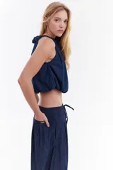 Blusa balloon de denim ultraliviano color gris oscuro, con escote halter fruncido, diseño sin mangas y dobladillo ajustado.