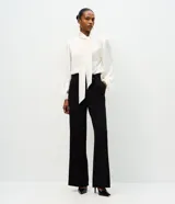Pantalón de corte wide leg confeccionado en crepé, con cintura alta que incluye hebilla decorativa y cierre frontal con cremallera.