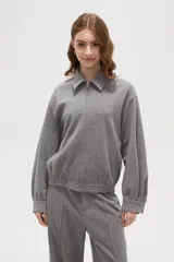 Campera de estilo deportivo en color gris, con cuello solapa, cierre frontal completo y mangas largas con puños ajustados. Presenta un diseño holgado con cintura elástica.