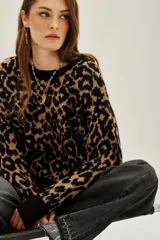 Sweater de punto con estampado animal print en tonos negro y tostado, de cuello redondo y mangas largas con puños acanalados.