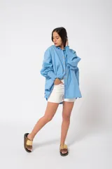 Camisa oversize color fucsia, de lino, con cuello camisero, cierre frontal con botones y mangas largas abullonadas con puños elásticos.