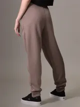 Pantalón de jogging color marrón claro, con cintura elástica, bolsillos laterales y logo de Calvin Klein en la cadera.