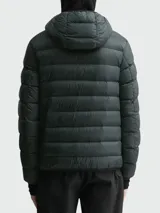 Campera corta acolchada de Moncler, modelo Alrai, en color gris oscuro. Presenta diseño de celdas horizontales, cierre frontal completo, capucha integrada y puños con aberturas para los pulgares.