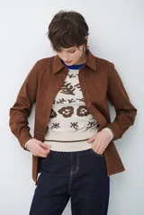 Camisa de estilo casual confeccionada en material tipo gamuza color marrón, con cuello clásico, cierre frontal con botones y costuras a la vista en tono contrastante.