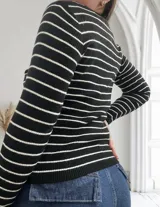 Sweater de punto a rayas horizontales blancas y negras, de manga larga y cuello redondo.