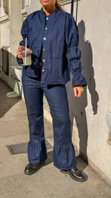 Pantalón de jean azul marino, de corte recto en la parte superior y con volados amplios en los bajos.