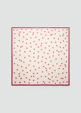 Pañuelo cuadrado de tejido satinado color beige con estampado de lunares rojos y borde rojo.