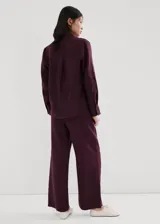 Pantalon de lino color bordo, de corte recto y tiro medio, con cintura elastizada y bolsillos laterales.