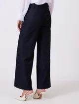 Pantalon de corte wide leg y tiro alto, con cintura estructurada, pasadores para cinturon y cierre frontal con gancho. Presenta bolsillos laterales de ojal y bolsillos traseros simulados, confeccionado en un tejido con caida fluida.
