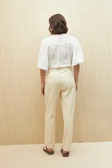 Pantalón negro de algodón, de tiro alto y corte recto, con bolsillos delanteros amplios con botones.