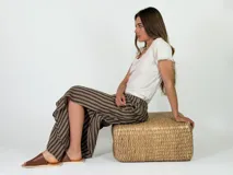 Pantalón de lino amplio y fluido, con diseño de rayas verticales en tonos beige y marrón, cintura elástica y corte relajado.