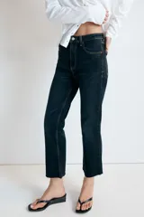 Jeans de tiro alto con cinco bolsillos, diseño cropped flare y bajo sin costuras. Cuenta con cierre frontal de cremallera y botón metálico.