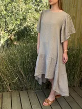 Vestido verde oliva de lino, corte suelto, con mangas abullonadas y volado en el ruedo.