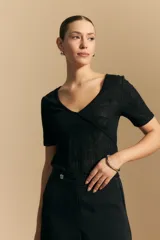 Top de manga corta confeccionado en tejido jacquard con textura en relieve. Presenta escote en V y un diseño frontal con líneas diagonales que crean un efecto cruzado.