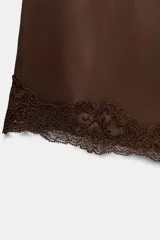 Short de satén color gris claro, con cintura elástica ajustable con cordones y bajo acabado con aplicación de encaje a tono.