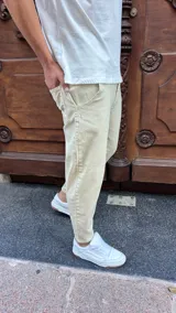 Pantalón tipo jeans de corte slouchy en color arena, con diseño de tiro medio, bolsillos laterales y ajuste cónico en los tobillos.