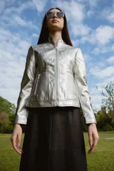 Campera plateada de símil cuero con cuello redondo, cierre frontal y bolsillos con cierre.