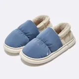 Pantuflas de plataforma con exterior de gamuza y forro interior de corderito sintético. Presentan un diseño sin talón con una tira decorativa ajustable mediante hebilla metálica lateral.