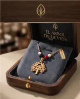 Collar de acero dorado con diseño de tres cadenas finas. El dije central representa un árbol de la vida calado, decorado con pequeñas cuentas de perla, ónix negro y cristal rojo.