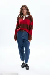 Sweater de tejido de punto con diseño a rayas horizontales anchas en color rojo y marrón oscuro. Posee cuello polo de color blanco y tapeta con botones.