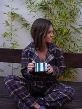 Conjunto de pijama a cuadros con ribetes en color lila, compuesto por camisa de manga larga con botones y pantalón largo.