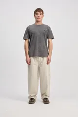 Pantalón de algodón color beige, de corte holgado y pierna amplia, con cintura elastizada y cordón ajustable.