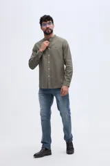 Camisa de lino y algodón color celeste, con cuello mao, cierre frontal de botones claros y pequeño bordado de pato en el pecho.