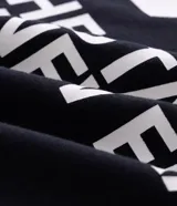 Remera de corte oversized confeccionada en mezcla de algodón y poliéster. Presenta cuello redondo, mangas cortas con hombros caídos y diseño estampado en la espalda con la frase 'LA THE START OF A NEW ERA' acompañada de estrellas amarillas.