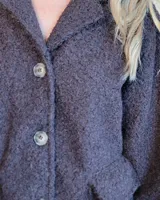 Sobrecamisa de paño color beige, con cuello solapa, cierre frontal de botones y dos bolsillos delanteros con solapa.