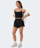 Short deportivo Fabletics Sunchaser color negro, con cintura ancha de punto, short interior ajustado y pequeñas aberturas laterales en el dobladillo.