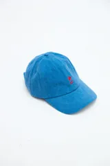 Gorra clásica de denim lavado azul con bordado rojo de una estrella y líneas en el frente, y visera curva.